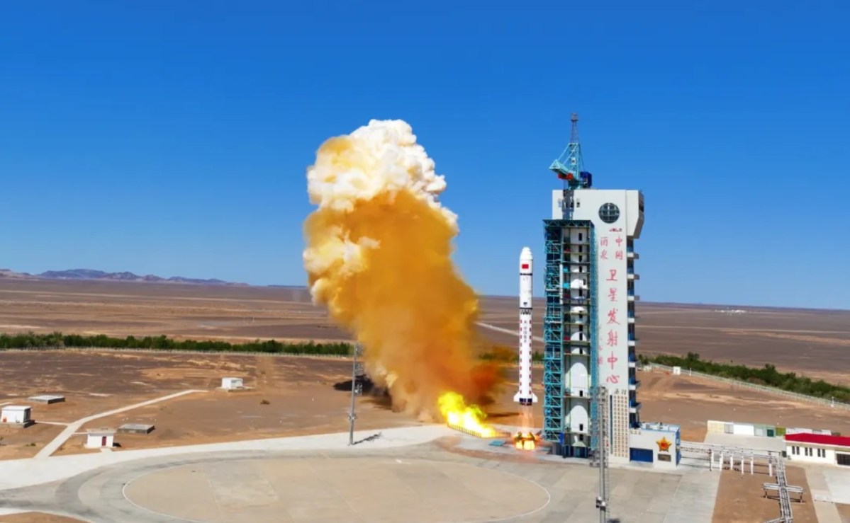 A Long March 2D rocket lifts off from Jiuquan Satellite Launch Center in northwest China, trailing bright yellow-orange exhaust against a clear blue sky, carrying the CSES-2 (Zhangheng-2) satellite on June 14, 2025