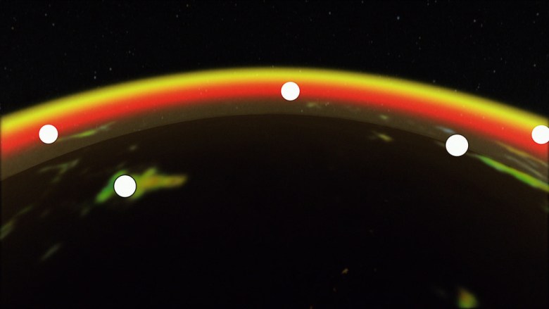 a red, yellow and orange arc crosses a black field. Six white dots along the arc represent satellites.