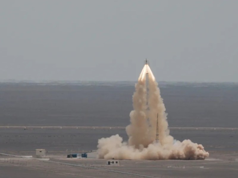 China’s Mengzhou crew spacecraft launches away from the pad during a successful pad abort test at Jiuquan Satellite Launch Center on June 17, 2025, with plumes of smoke and dust rising from the desert launch site.