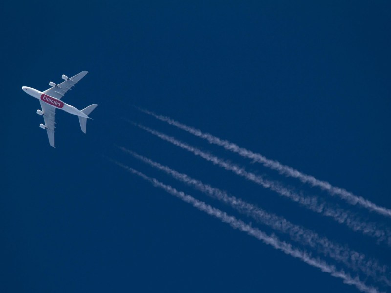 View of a large commercial plane leaving contrails in the sky.